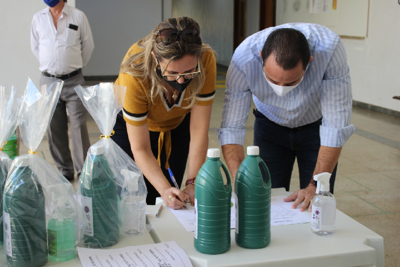 Diretora-geral do Câmpus Aparecida de Goiânia do IFG, professora Ana Lucia Siqueira de Oliveira, e vice-prefeito de Aparecida de Goiânia, Veter Martins Morais, formalizando a entrega dos kits saneantes em assinatura de termo